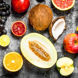 variety of fresh fruits. On rustic background .